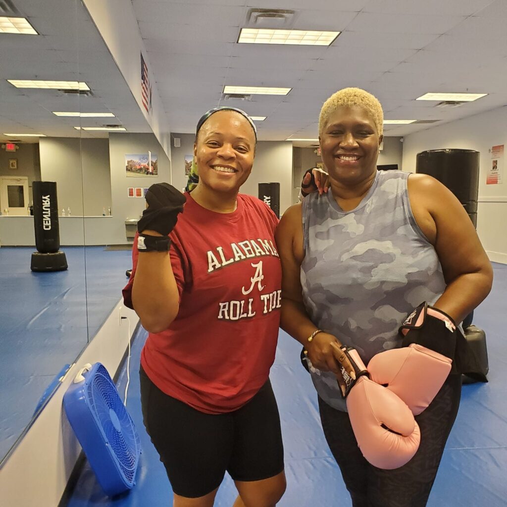 Women doing cardio kickboxing together indoors