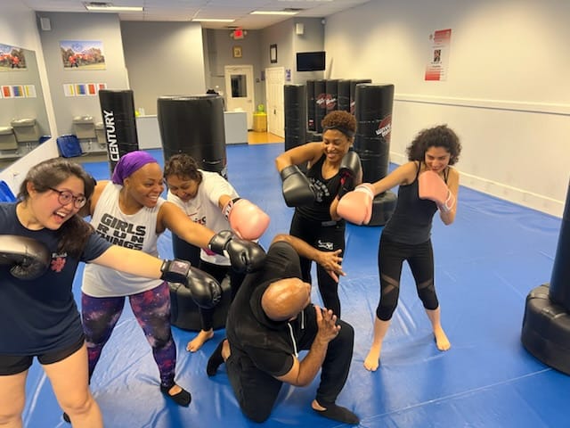 "Woman kickboxing to reduce stress at Shape Up Kickboxing studio"
