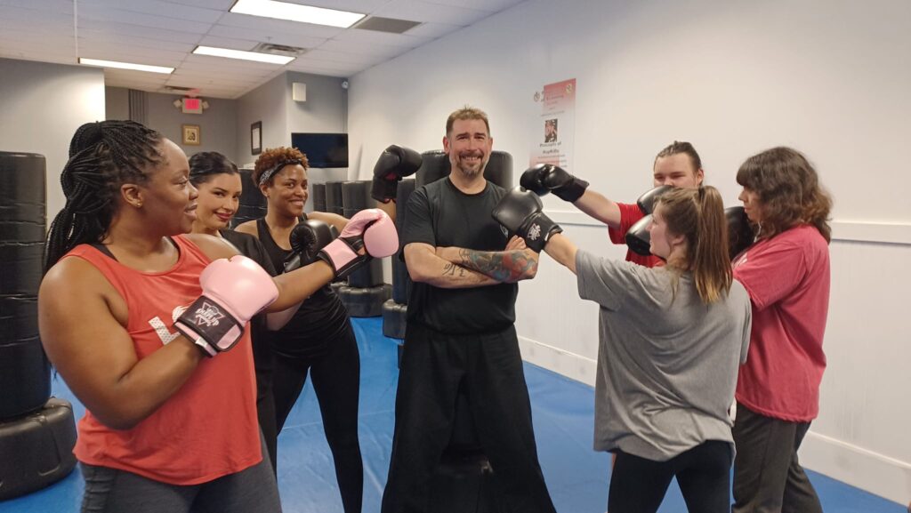 Participants enjoying a high-energy kickboxing group fitness class at Shape Up Kickboxing