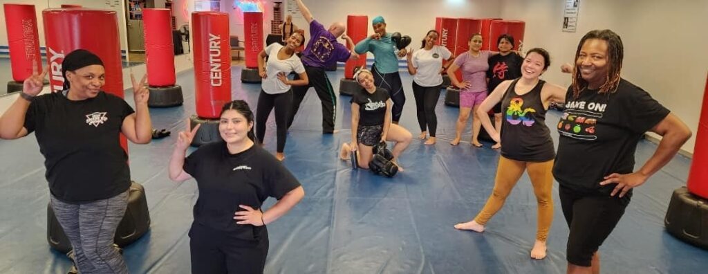 Smiling woman throwing a punch in a fitness kickboxing class